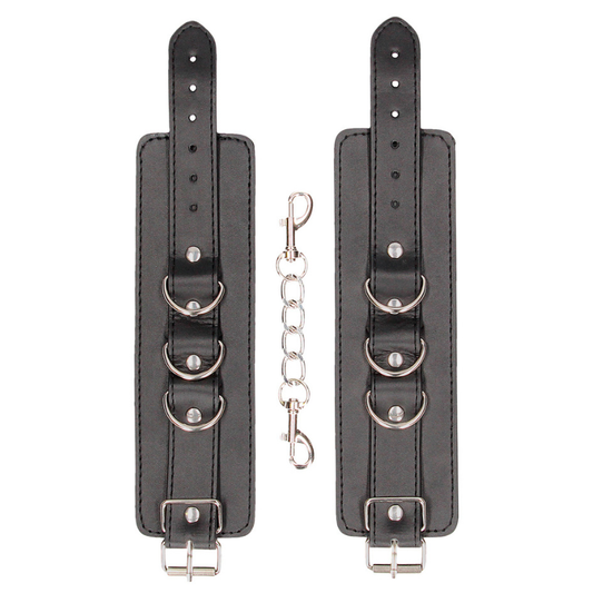 Menottes cuir Ouch! en cuir noir avec anneaux métalliques pour jeux BDSM et domination.