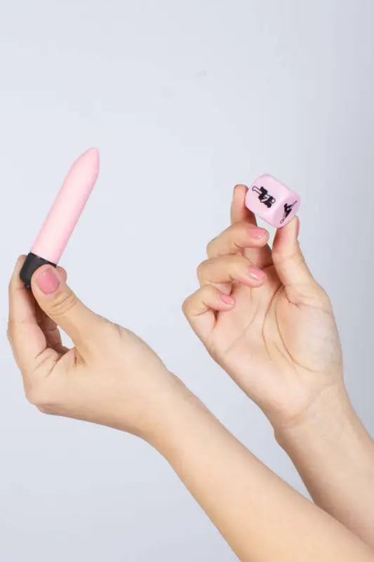 Vibrateur rose et dé sexuel.