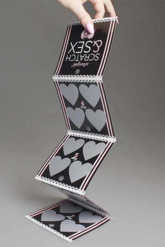 Carte à gratter pliée avec des zones de grattage en forme de cœur.