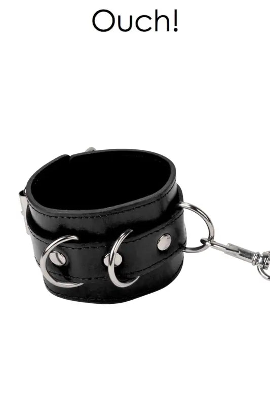 Manchette de contention en cuir noir avec matériel métallique.